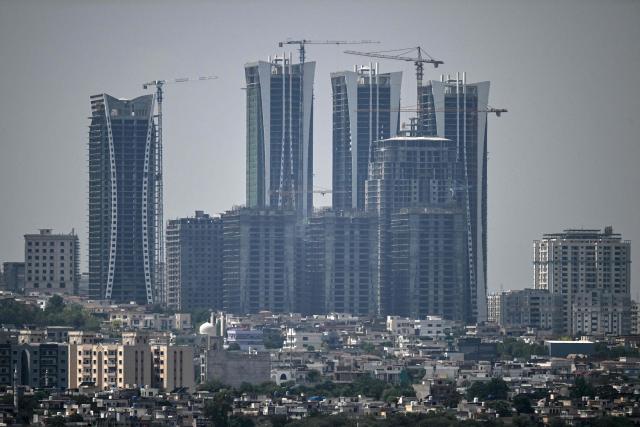 Cranes operate next to newly constructed high-rise buildings on the outskirts of Islamabad on June 14, 2026. Pakistan's government presented its annual budget on June 12, including plans to boost tax collection and defence spending, as citizens expressed weariness with surging inflation sparked by the Middle East crisis that Islamabad is mediating to end. (Photo by Aamir QURESHI / AFP)