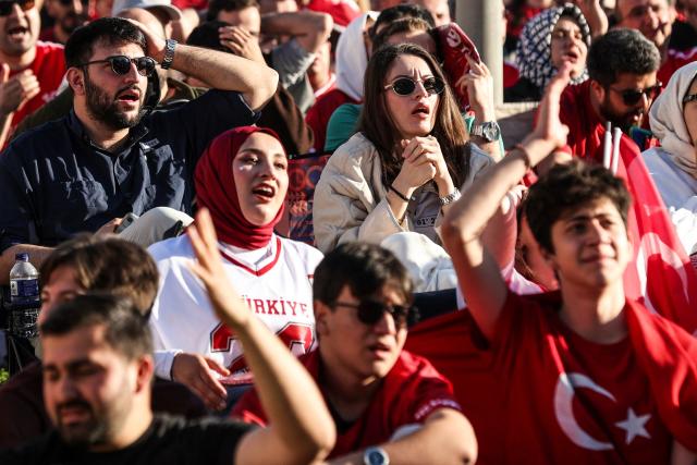 Turkish fans react as they watch a broadcast of the FIFA World Cup 2026 Group D match between Australia and Turkey at the Yedikule fortress, which encloses a section of the ancient Walls of Constantinople, in Istanbul on June 14, 2026. (Photo by BERK OZKAN / AFP)