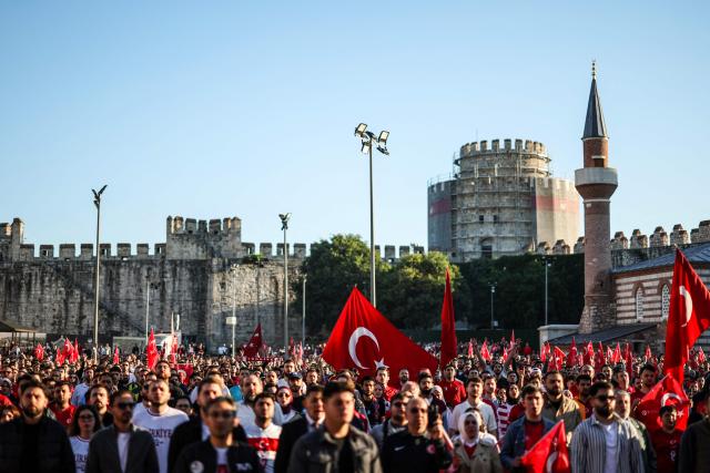 Turkish fans weaves Turkish national flags as they watch a broadcast of the FIFA World Cup 2026 Group D match between Australia and Turkey at the Yedikule fortress, which encloses a section of the ancient Walls of Constantinople, in Istanbul on June 14, 2026. (Photo by BERK OZKAN / AFP)