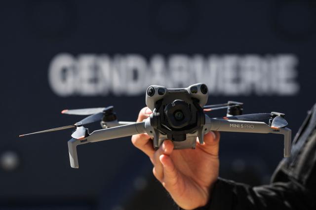 A gendarme belonging to the Armoured Mobile Gendarmerie Unit (GBGM) holds a drone during a dynamic demonstration of military equipment at the Eurosatory trade show, dedicated to defense and security, at the Paris Nord Villepinte Exhibition Center in Villepinte, northeastern suburb of Paris on June 14, 2026. The Eurosatory trade show takes place from June 15 to 19, 2026. (Photo by Kenzo TRIBOUILLARD / AFP)