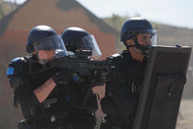 A gendarme (L) aims with HK Hum 9 mm submachine gun during a dynamic demonstration of military equipment at the Eurosatory trade show, dedicated to defense and security, at the Paris Nord Villepinte Exhibition Center in Villepinte, northeastern suburb of Paris on June 14, 2026. The Eurosatory trade show takes place from June 15 to 19, 2026. (Photo by Kenzo TRIBOUILLARD / AFP)