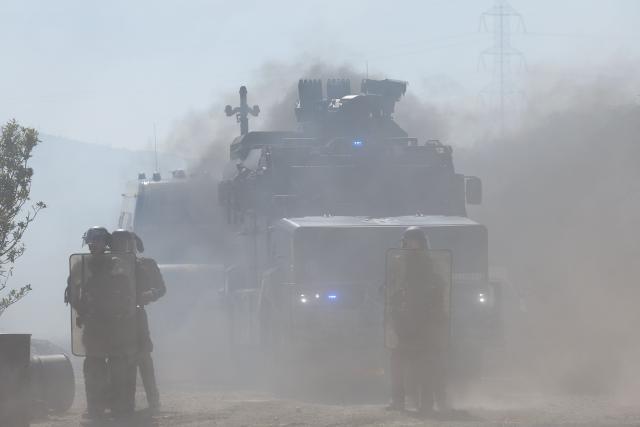 Gendarmes of the Armoured Mobile Gendarmerie Unit (GBGM) participate in a military equipment demonstration at the Eurosatory defence and security trade show at the Paris Nord Villepinte Exhibition Centre in Villepinte, a northeastern suburb of Paris, on June 14, 2026. The Eurosatory trade show takes place from June 15 to 19, 2026. (Photo by Kenzo TRIBOUILLARD / AFP)