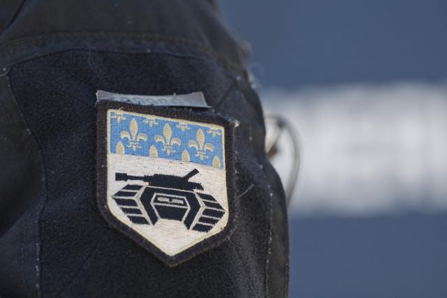 A gendarme belonging to the Armoured Mobile Gendarmerie Unit (GBGM) displays the unit's badge during a dynamic demonstration of military equipment at the Eurosatory trade show, dedicated to defense and security, at the Paris Nord Villepinte Exhibition Center in Villepinte, northeastern suburb of Paris on June 14, 2026. The Eurosatory trade show takes place from June 15 to 19, 2026. (Photo by Kenzo TRIBOUILLARD / AFP)