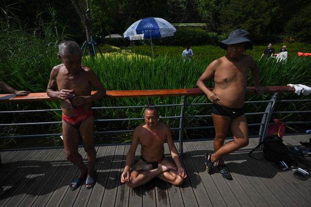 Men gather to dive into the Liangma River in Beijing on June 14, 2026. (Photo by Pedro PARDO / AFP)