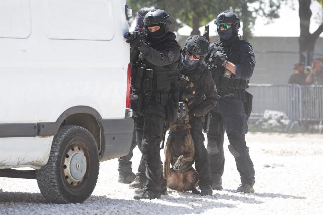 French policemen of the Search and Intervention Brigade (BRI) with a police dog participate during a dynamic demonstration of military equipment at the Eurosatory trade show, dedicated to defense and security, at the Paris Nord Villepinte Exhibition Center in Villepinte, northeastern suburb of Paris on June 14, 2026. The Eurosatory trade show takes place from June 15 to 19, 2026. (Photo by Kenzo TRIBOUILLARD / AFP)