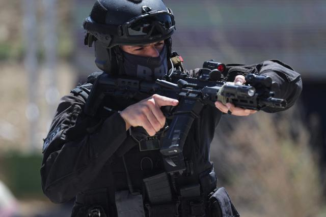 A policeman of the Search and Intervention Brigade (BRI) aims a machine gun during a dynamic demonstration of military equipment at the Eurosatory trade show, dedicated to defense and security, at the Paris Nord Villepinte Exhibition Center in Villepinte, northeastern suburb of Paris on June 14, 2026. The Eurosatory trade show takes place from June 15 to 19, 2026. (Photo by Kenzo TRIBOUILLARD / AFP)
