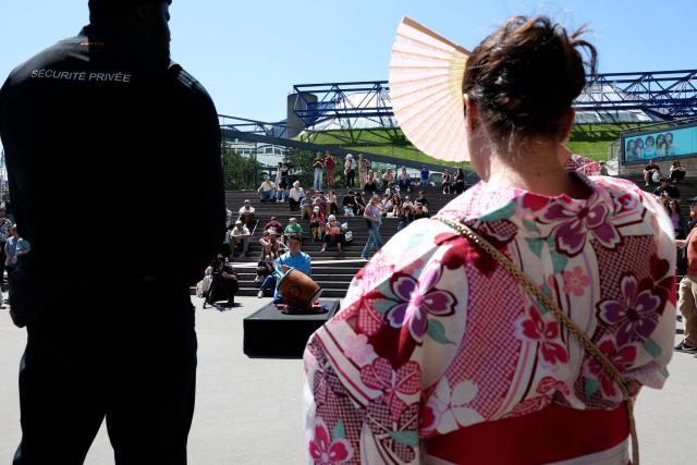 A woman, wearing a kimono, watches a drummer making the sumo annoucement (Yose-daiko) outside the Accor Arena on day 2 of the 2026 Paris Sumo Tournament, in Paris on June 14, 2026. (Photo by Behrouz MEHRI / AFP)