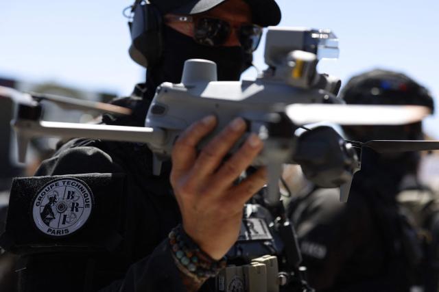 A French policeman of the Search and Intervention Brigade (BRI) holds a Matrice 4T drone during a dynamic demonstration of military equipment at the Eurosatory trade show, dedicated to defense and security, at the Paris Nord Villepinte Exhibition Center in Villepinte, northeastern suburb of Paris on June 14, 2026. The Eurosatory trade show takes place from June 15 to 19, 2026. (Photo by Kenzo TRIBOUILLARD / AFP)