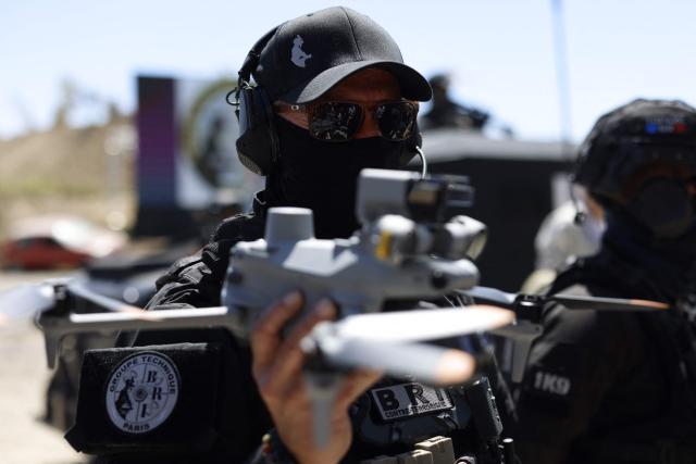 A French policeman of the Search and Intervention Brigade (BRI) holds a Matrice 4T drone during a dynamic demonstration of military equipment at the Eurosatory trade show, dedicated to defense and security, at the Paris Nord Villepinte Exhibition Center in Villepinte, northeastern suburb of Paris on June 14, 2026. The Eurosatory trade show takes place from June 15 to 19, 2026. (Photo by Kenzo TRIBOUILLARD / AFP)