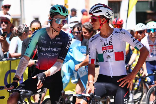 Decathlon CMA CGM Team's French rider Paul Seixas (L) and UAE Team Emirates XRG's Mexican rider Isaac Del Toro Romero speak at the start line before the 8th and final stage of the Tour Auvergne-Rhone-Alpes cycling race (formerly known as the Criterium du Dauphine), 120,1km between Beaufort and Plateau de Solaison, in the French Alps on June 14, 2026. (Photo by Anne-Christine POUJOULAT / AFP)
