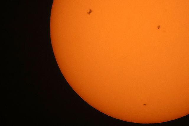 The International Space Station (ISS), (Top-L) transits the sun as seen from Shuwaikh industrial  district in Kuwait City on June 14, 2026. (Photo by YASSER AL-ZAYYAT / AFP)