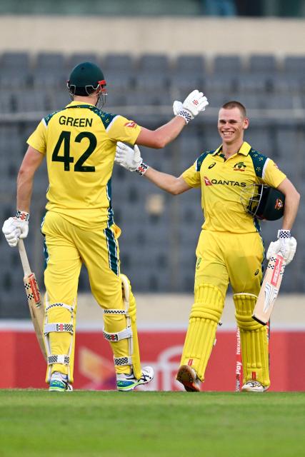 Australia's Cooper Connolly (R) celebrates with teammate Cameron Green after scoring a century (100 runs) during the third one-day international (ODI) cricket match between Bangladesh and Australia at the Sher-e-Bangla National Stadium in Dhaka on June 14, 2026. (Photo by Munir UZ ZAMAN / AFP)