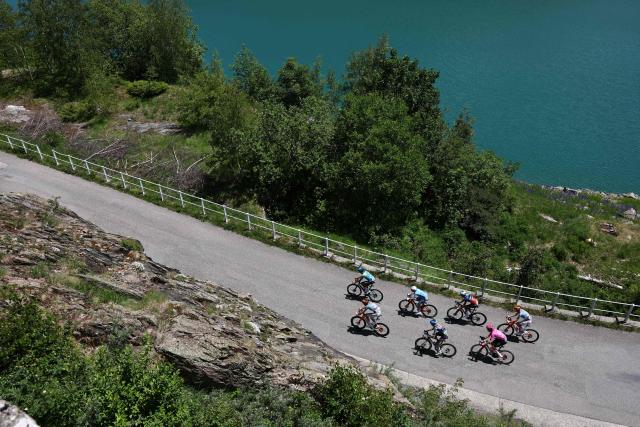 The lead breakaway cycles along the Lac de Roselend during the 8th and final stage of the Tour Auvergne-Rhone-Alpes cycling race (formerly known as the Criterium du Dauphine), 120,1km between Beaufort and Plateau de Solaison, in the French Alps on June 14, 2026. (Photo by Anne-Christine POUJOULAT / AFP)