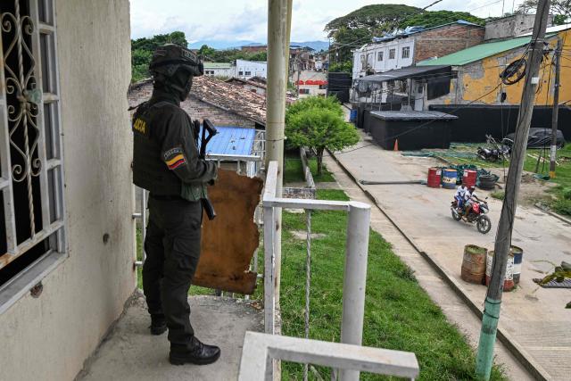 A police officer stands guard overlooking the damaged City Hall next to the Buenos Aires police station in Buenos Aires, Cauca department, Colombia, on June 13, 2026, months after it was heavily attacked. Colombia will hold the runoff presidential election on June 21. (Photo by JOAQUIN SARMIENTO / AFP)