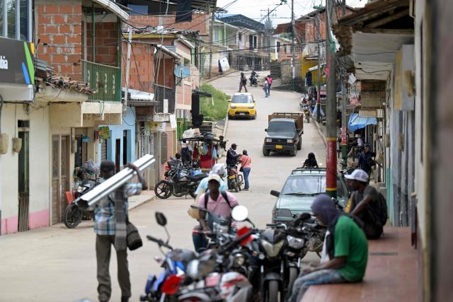 People go about their daily activities on the main street of the town of Buenos Aires in Cauca department, Colombia, on June 13, 2026. Colombia will hold the runoff presidential election on June 21. (Photo by JOAQUIN SARMIENTO / AFP)