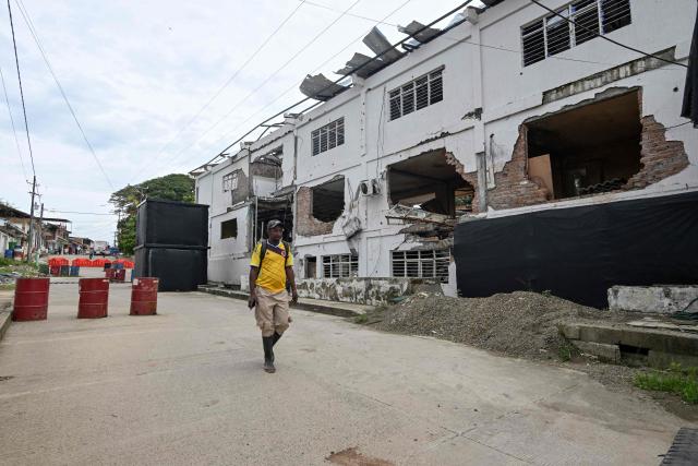 A man walks past the Buenos Aires police station, months after it was heavily attacked, in Buenos Aires, Cauca department, Colombia, on June 13, 2026. Colombia will hold the runoff presidential election on June 21. (Photo by JOAQUIN SARMIENTO / AFP)