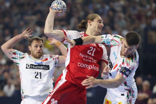 Aalborg's German centre back #21 Juri Knorr (C) and SC Magdeburg's Icelandic left back Elvar Orn Jonsson vie for the ball during the EHF Men's Handball Champions League Final 4 third place match between Aalborg Handbold and SC Magdeburg in Cologne, western Germany on June 14, 2026. (Photo by Ronny HARTMANN / AFP)