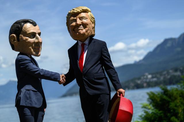 Demonstrators dressed up with caricature "big heads" representing the G7 heads of state (from L) France's President Emmanuel Macron and US President Donald Trump, pose during a happening organised by the NGO OXFAM, in Publier eastern France, on June 14, 2026. A G7 summit is set to take place June 15 to 17 in the French town of Evian-les-Bains near Switzerland and it will be attended by country leaders as well as the EU's foreign policy chief and ministers from Brazil, Canada, the United Arab Emirates and Turkey. (Photo by JEFF PACHOUD / AFP)
