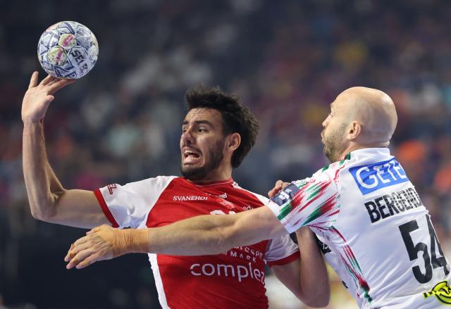 Aalborg's Danish left back #25 Marinus Grandahl Munk (L) and SC Magdeburg's Swedish pivot Oscar Bergendahl vie for the ball during the EHF Men's Handball Champions League Final 4 third place match between Aalborg Handbold and SC Magdeburg in Cologne, western Germany on June 14, 2026. (Photo by Ronny HARTMANN / AFP)