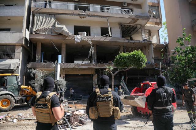 Lebanese army soldiers stand guard as people clear the rubble at the site of an Israeli airstrike that targeted a building in Beirut’s southern suburbs on June 14, 2026. The office of Israeli Prime Minister Benjamin Netanyahu said on June 14 the military had carried out strikes in Beirut's southern suburbs, known as Dahiyeh, while Lebanese state media said a strike hit the Ghobeiry neighbourhood. A senior Iranian military official warned that Israel's strike would not go "unanswered" by Tehran, according to local media. (Photo by Ibrahim AMRO / AFP) / 