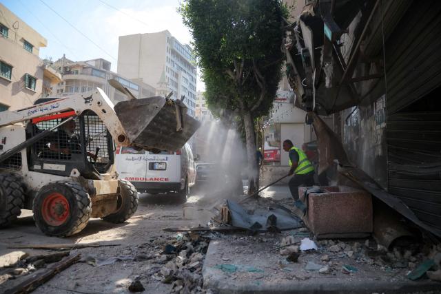 People clear the rubble at the site of an Israeli airstrike that targeted a building in Beirut’s southern suburbs on June 14, 2026. The office of Israeli Prime Minister Benjamin Netanyahu said on June 14 the military had carried out strikes in Beirut's southern suburbs, known as Dahiyeh, while Lebanese state media said a strike hit the Ghobeiry neighbourhood. A senior Iranian military official warned that Israel's strike would not go "unanswered" by Tehran, according to local media. (Photo by Ibrahim AMRO / AFP) / 