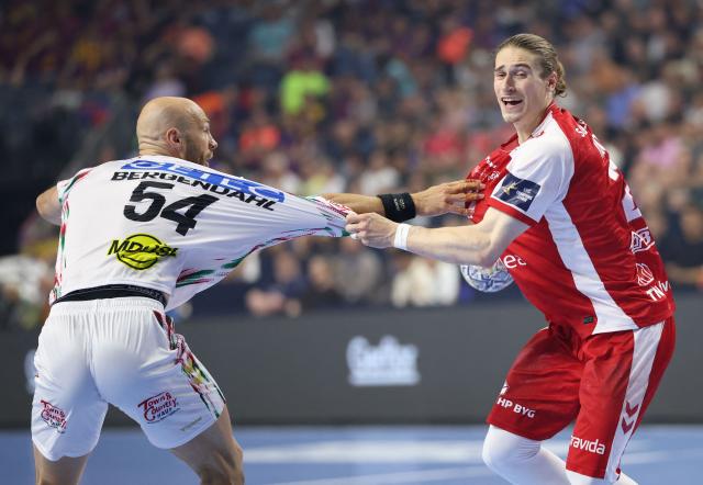 SC Magdeburg's Swedish pivot Oscar Bergendahl (L) and Aalborg's German centre back #21 Juri Knorr vie for the ball during the EHF Men's Handball Champions League Final 4 third place match between Aalborg Handbold and SC Magdeburg in Cologne, western Germany on June 14, 2026. (Photo by Ronny HARTMANN / AFP)
