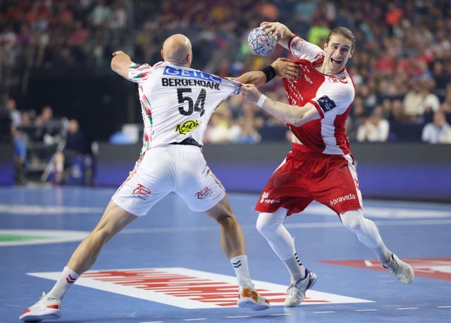 SC Magdeburg's Swedish pivot Oscar Bergendahl (L) and Aalborg's German centre back #21 Juri Knorr vie for the ball during the EHF Men's Handball Champions League Final 4 third place match between Aalborg Handbold and SC Magdeburg in Cologne, western Germany on June 14, 2026. (Photo by Ronny HARTMANN / AFP)