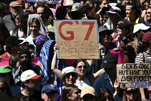 Demonstrators hold placards during a demonstration of a "No-G7" coalition of over 60 associations, unions and left-wing groups "against fascism and imperialism, a day ahead of the summit's start, in Geneva on June 14, 2026. The 2026 edition of the G7 summit is set to take place June 15 to 17 in the French town of Evian-les-Bains near Switzerland, attended by country leaders as well as the EU's foreign policy chief and ministers from Brazil, Canada, the United Arab Emirates and Turkey. (Photo by Fabrice COFFRINI / AFP)