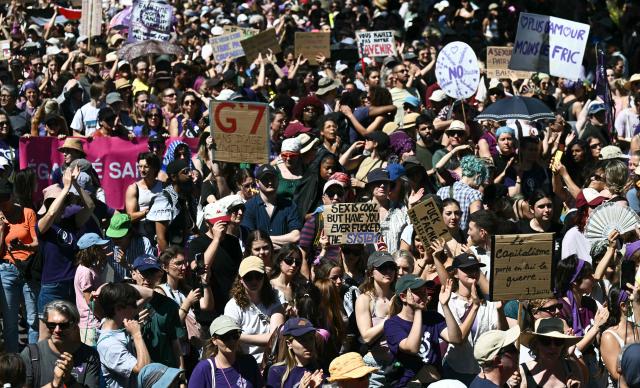 Demonstrators hold placards during a demonstration of a "No-G7" coalition of over 60 associations, unions and left-wing groups "against fascism and imperialism, a day ahead of the summit's start, in Geneva on June 14, 2026. The 2026 edition of the G7 summit is set to take place June 15 to 17 in the French town of Evian-les-Bains near Switzerland, attended by country leaders as well as the EU's foreign policy chief and ministers from Brazil, Canada, the United Arab Emirates and Turkey. (Photo by Fabrice COFFRINI / AFP)