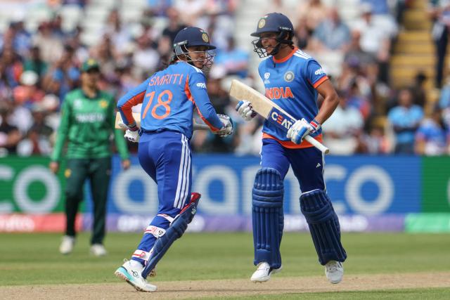 India's Smriti Mandhana (C) and India's captain Harmanpreet Kaur (R) run between the stumps during the ICC Women's T20 cricket World Cup 2026 Group A stage, Match 6 match between the India and Pakistan at Edgbaston cricket ground in Birmingham, central England on June 14, 2026. (Photo by Darren Staples / AFP)
