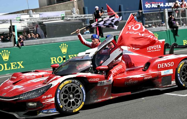 British driver Mike Conway, Japanese driver Kamui Kobayashi and Dutch driver Nyck de Vries celebrate on their Toyota #7 after winning the 94th edition of the 24 Hours of Le Mans at the Le Mans circuit, north-western France, on June 14, 2026. (Photo by LOU BENOIST / AFP)