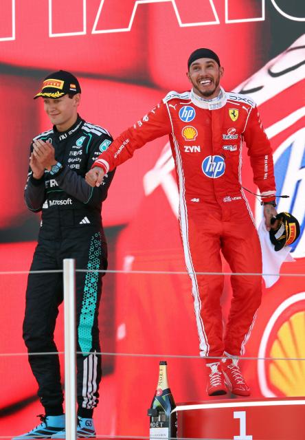 Winner Ferrari's British driver Lewis Hamilton (R) and second placed Mercedes' British driver George Russell celebrate in the podium after the Catalonia Formula One Grand Prix at the Circuit de Catalunya in Montmelo, on the outskirts of Barcelona, on June 14, 2026. (Photo by Lluis GENE / AFP)