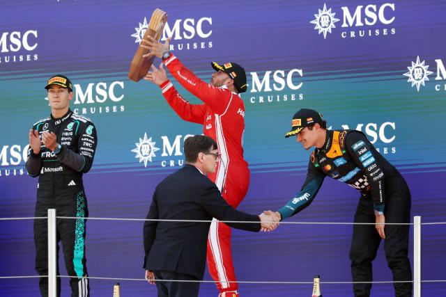 Winner Ferrari's British driver Lewis Hamilton, second placed Mercedes' British driver George Russell (L) and third placed McLaren's British driver Lando Norris (R) celebrate in the podium after the Catalonia Formula One Grand Prix at the Circuit de Catalunya in Montmelo, on the outskirts of Barcelona, on June 14, 2026. (Photo by Lluis GENE / AFP)