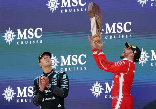 Winner Ferrari's British driver Lewis Hamilton (R) and second placed Mercedes' British driver George Russell celebrate in the podium after the Catalonia Formula One Grand Prix at the Circuit de Catalunya in Montmelo, on the outskirts of Barcelona, on June 14, 2026. (Photo by Lluis GENE / AFP)