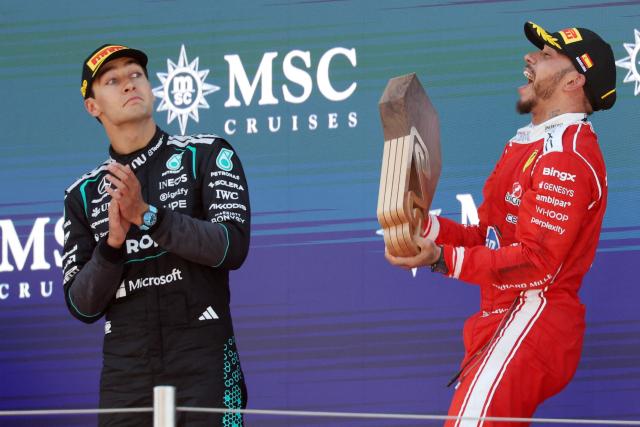 Winner Ferrari's British driver Lewis Hamilton (R) and second placed Mercedes' British driver George Russell celebrate in the podium after the Catalonia Formula One Grand Prix at the Circuit de Catalunya in Montmelo, on the outskirts of Barcelona, on June 14, 2026. (Photo by Lluis GENE / AFP)