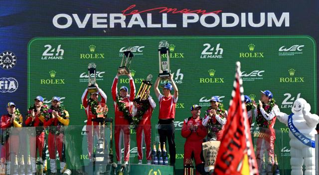 The Toyota #7 drivers British Mike Conway, Japanese Kamui Kobayashi and Dutch Nyck de Vries celebrate on the podium after winning the 94th edition of the 24 Hours of Le Mans at the Le Mans circuit, north-western France, on June 14, 2026. (Photo by LOU BENOIST / AFP)