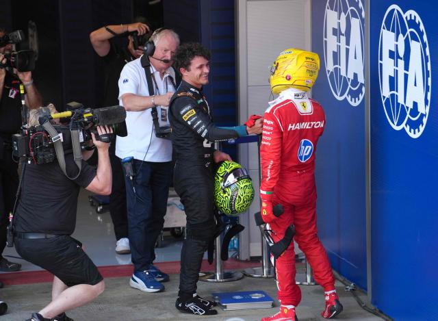 Ferrari's British driver Lewis shakes hands with McLaren's British driver Lando Norris after winning the Catalonia Formula One Grand Prix at the Circuit de Catalunya in Montmelo, on the outskirts of Barcelona, on June 14, 2026. (Photo by Manaure QUINTERO / AFP)
