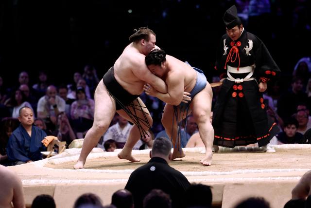 Ukranian sumo wrestler Aonishiki (L) battles with Japanese sumo wrestler Tobizaru during their bout on day 2 of the 2026 Paris Sumo Tournament, in Paris on June 14, 2026. (Photo by Behrouz MEHRI / AFP)