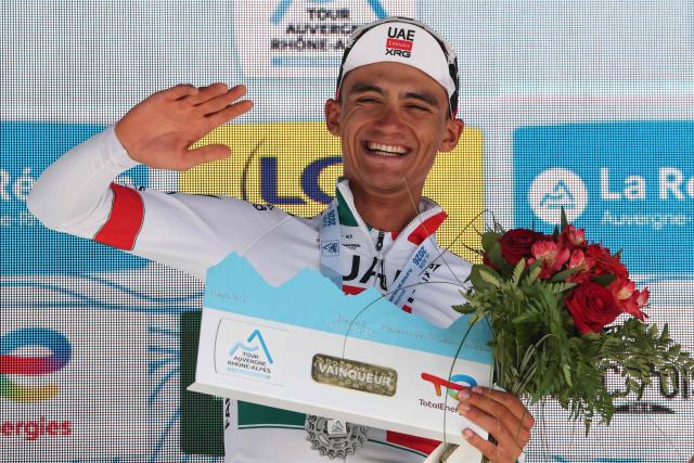 UAE Team Emirates XRG's Mexican rider Isaac Del Toro Romero celebrates his overall victory on the podium after winning the 8th and final stage of the Tour Auvergne-Rhone-Alpes cycling race (formerly known as the Criterium du Dauphine), 120,1km between Beaufort and Plateau de Solaison, in the French Alps on June 14, 2026. (Photo by Anne-Christine POUJOULAT / AFP)