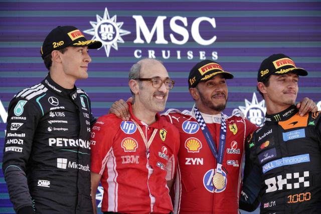 Winner Ferrari's British driver Lewis Hamilton (2R) celebrates with Ferrari's race engineer Carlo Santi (2L), second placed Mercedes' British driver George Russell (L) and third placed McLaren's British driver Lando Norris on the podium after the Catalonia Formula One Grand Prix at the Circuit de Catalunya in Montmelo, on the outskirts of Barcelona, on June 14, 2026. (Photo by Manaure Quintero / AFP)