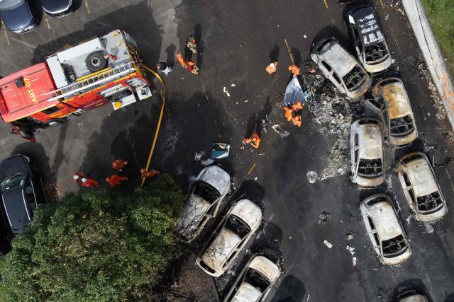An aerial view shows firefighters working at the site of a helicopter crash in the Recreio dos Bandeirantes neighbourhood in Rio de Janeiro, Brazil, on June 14, 2026. At least six people died in Brazil on June 14 after two helicopters crashed in western Rio de Janeiro, after a suspected mid-air collision, firefighters said. (Photo by Tercio TEIXEIRA / AFP)