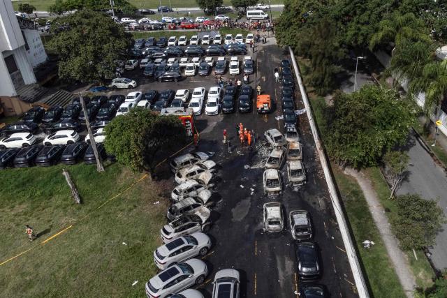An aerial view shows the aftermath of a helicopter crash in the Recreio dos Bandeirantes neighbourhood in Rio de Janeiro, Brazil, on June 14, 2026. At least six people died in Brazil on June 14 after two helicopters crashed in western Rio de Janeiro, after a suspected mid-air collision, firefighters said. (Photo by Tercio TEIXEIRA / AFP)