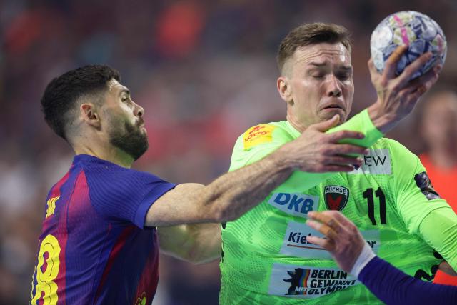 Fuechse Berlin's Danish left back Lasse Andersson (R) and FC Barcelona's Slovenian right wing #18 Blaz Janc vie for the ball during the EHF Men's Handball Champions League Final 4 final between Barca and Fuechse Berlin in Cologne, western Germany on June 14, 2026. (Photo by Ronny HARTMANN / AFP)