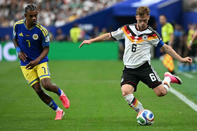 Germany's midfielder #06 Joshua Kimmich (R) passes the ball next to Curacao's midfielder #07 Juninho Bacuna during the 2026 World Cup Group E football match between Germany and Curacao at the Houston Stadium in Houston on June 14, 2026.  (Photo by Paul ELLIS / AFP)