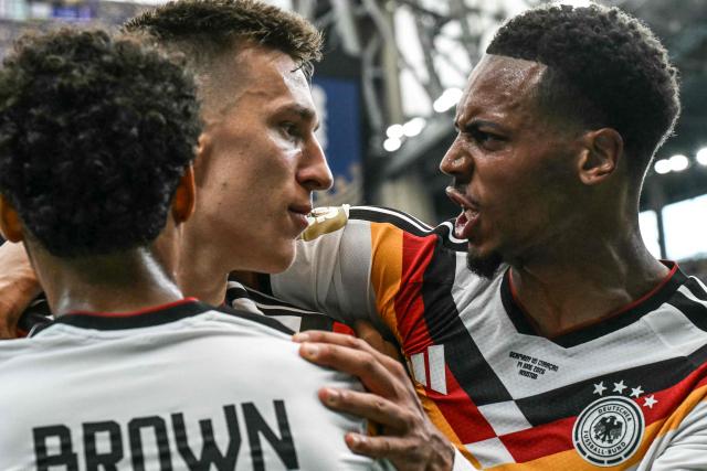 Germany's defender #15 Nico Schlotterbeck (C) celebrates with Germany's defender #23 Felix Nmecha (C) and Germany's defender #18 Nathaniel Brown (L) after scoring his team's second goal during the 2026 World Cup Group E football match between Germany and Curacao at the Houston Stadium in Houston on June 14, 2026.  (Photo by RONALDO SCHEMIDT / AFP)