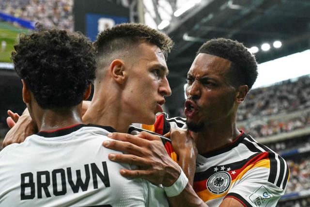 Germany's defender #15 Nico Schlotterbeck (C) celebrates with Germany's defender #23 Felix Nmecha (C) and Germany's defender #18 Nathaniel Brown (L) after scoring his team's second goal during the 2026 World Cup Group E football match between Germany and Curacao at the Houston Stadium in Houston on June 14, 2026.  (Photo by RONALDO SCHEMIDT / AFP)