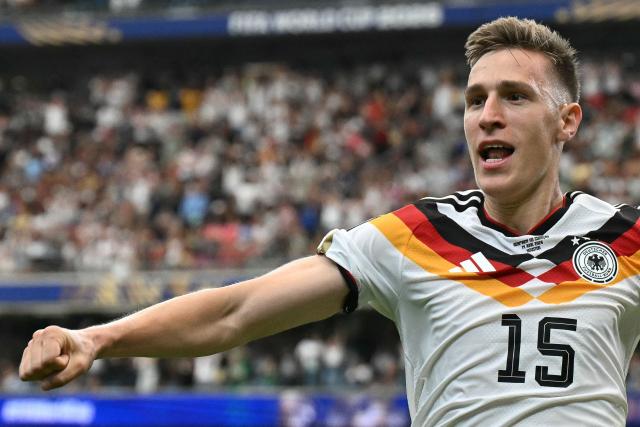 Germany's defender #15 Nico Schlotterbeck (C) celebrates with Germany's defender #18 Nathaniel Brown (L) after scoring his team's second goal  during the 2026 World Cup Group E football match between Germany and Curacao at the Houston Stadium in Houston on June 14, 2026.  (Photo by RONALDO SCHEMIDT / AFP)