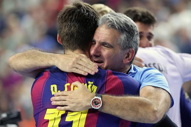 FC Barcelona's Spanish headcoach Antonio Carlos Ortega Perez (R) and  FC Barcelona's Bosnian-born right back #11 Djordje Cikusa celebrate after winning the EHF Men's Handball Champions League Final 4 final between Barca and Fuechse Berlin in Cologne, western Germany on June 14, 2026. Barca won the match 37:34. (Photo by Ronny HARTMANN / AFP) / ALTERNATIVE CROP