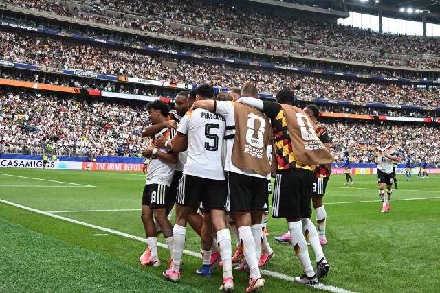 Germany's defender #18 Nathaniel Brown (L) is congratulated by teammates after scoring a goal during the 2026 World Cup Group E football match between Germany and Curacao at the Houston Stadium in Houston on June 14, 2026.  (Photo by Paul ELLIS / AFP)