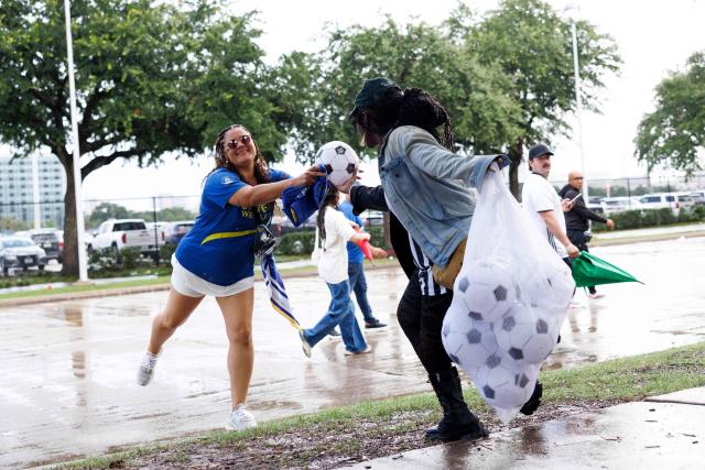 An Organized Power In Numbers (OPIN) staff member distributes soccer balls with “ICE OUT” messages outside of Houston Stadium in Houston, Texas, on June 14, 2026 before the 2026 World Cup Group E football match between Germany and Curacao. (Photo by Mark Felix / AFP)